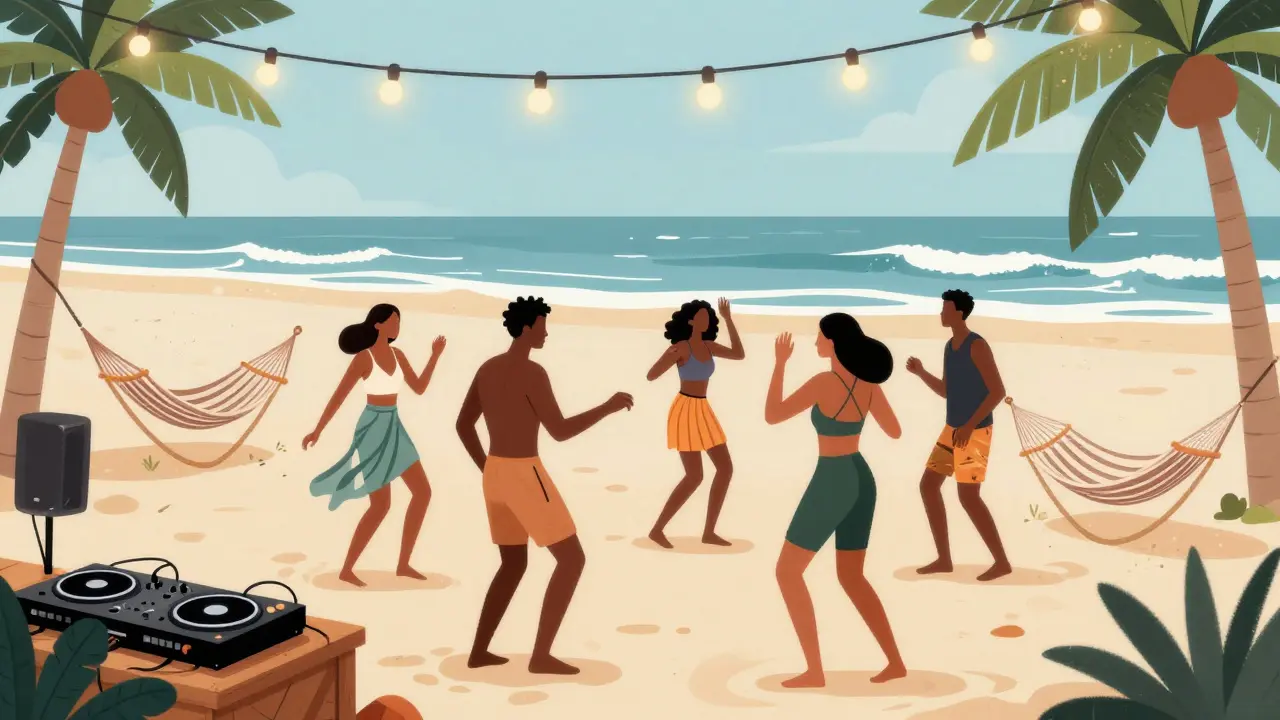 People dancing on a beach under string lights with ocean waves and palm trees at night.