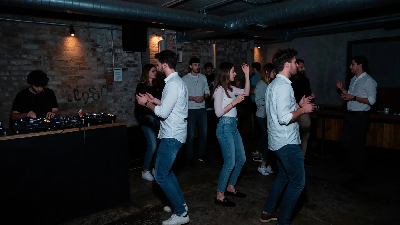 Dim underground club with a small crowd dancing to deep house music under strobe lights.